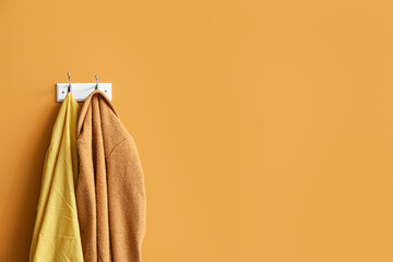 Hanger with clothes on color background