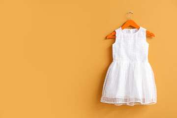 Hanger with dress on color background