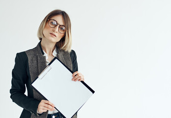 a woman in a formal suit holds a white sheet of paper in her hands Copy Space