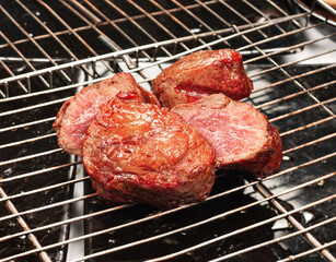 The meat is cooked on the grill with the grill