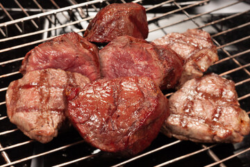 The meat is cooked on the grill with the grill