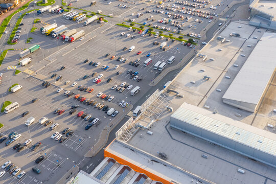 Aerial top down view of the parking lot with many cars of supermarket shopping center shoppers in the city grocery store.