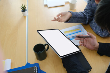 Two successful businesspeople using digital tablet and analyzing data report about company development in office.