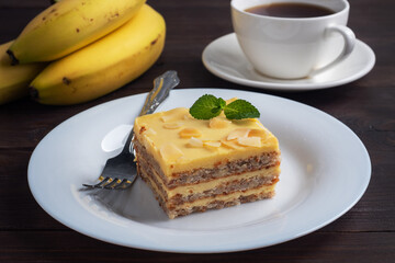 Banana sponge cake with nuts and mint. Delicious sweet dessert for tea, Dark wooden background.