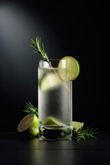 Cold refreshing drink with ice, lime, and rosemary.