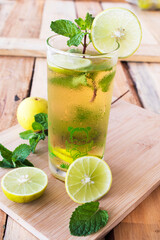 herbal healthy drinks cold lemon juice for health care with peppermint leaf and lemon slice on background wooden