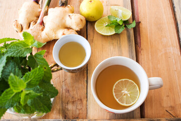 herbal healthy drinks hot tea honey lemon for health care with peppermint leaf and lemon slice for relaxation arrangement flat lay style on background  wooden