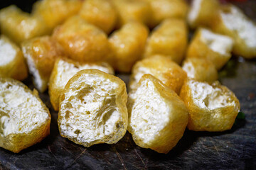 Avocado cut on a chopping board, deep-fried tofu