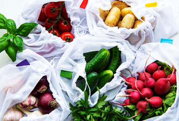 Mesh shopping bag with organic vegetables on marble background. Flat lay, top view. Zero waste, plastic free concept.  Summer fruits.