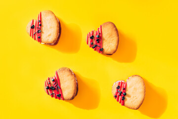 Heart-shaped cakes are positioned in the middle of yellow background. Homemade cakes for holiday, party and gift to your loved one