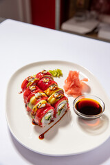 Close up of spicy tuna sushi roll served on a white plate