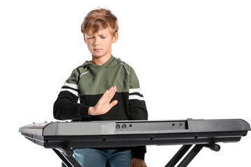 Little boy refusing to play synthesizer on white background