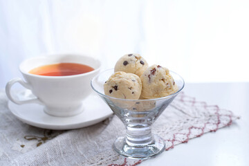 Ice cream scoops shaped cookies and a cup of tea on napery cloth, selective focus, cookies that look like scoop ice cream