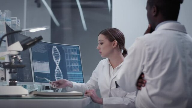 Diverse scientists studying medical samples and human skeleton. Using computers and microscopes. Modern laboratory interior