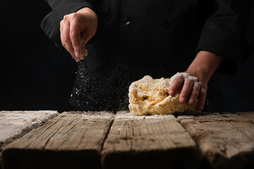 chef cooks on a black background, baked goods or bread, freeze in motion. signboard, homemade...