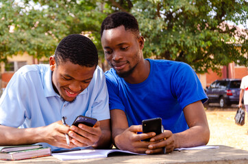 two young handsome african brothers got excited about what they saw on their cellphone