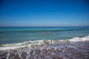Two boys surfing together off of the beach of the Pacific Ocean in Lo de Marcos, Riviera Nayarit, Mexico.