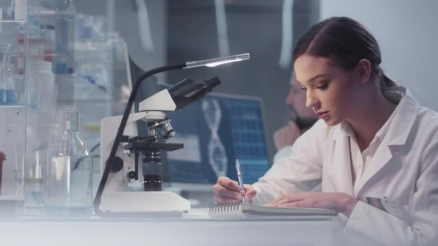 Diverse scientists studying medical samples and human skeleton. Using computers and microscopes. Modern laboratory interior