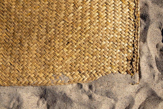 A handmade traditional sleeping mat called a "petate". Here it is used as a beach blanket on the sand.