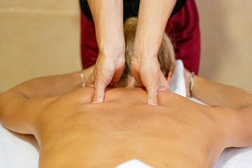 Chiromassage therapist giving a back massage to a client
