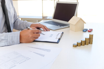 Sales manager giving advice application form document, considering mortgage loan offer for car and house insurance.