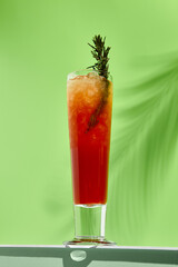 Mango and berries lemonades drink on white table. Green wall in sunlight with palm leaf hard shadow. Summer, tropic, fresh drink concept