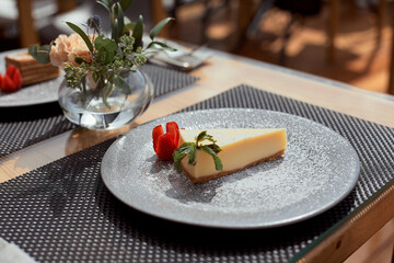 Slice of layered honey cake russian Medovik decorated with mint and almonds on white plate