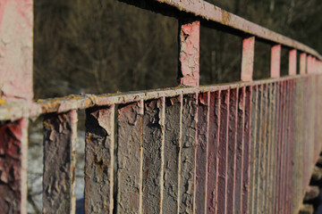 bridge railing with old, cracked paint and rust, background