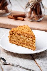 Closeup on slice of sweet honey cake on the wooden table