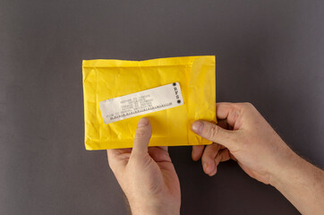 Hands hold a yellow mail bag that says RETURN TO SENDER.