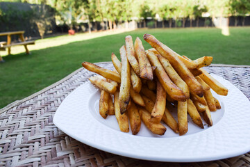 Crispy crunchy French fries heap. Potato finger chips with seasoning masala. Very tasty popular teatime snack item worldwide eaten. Potato deep fried snacks served outdoors