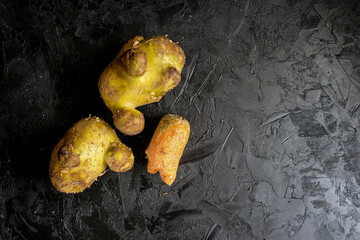 Trendy ugly organic produce  - Several carrots and potatoes lie on a wooden gray table. Сopy...