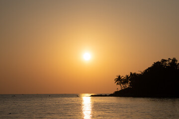 Fototapeta na wymiar Sunset ocean view. Sun above the sea on orange sky.