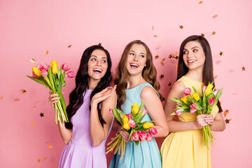 Photo of optimistic nice long hairdo ladies hold flowers look empty space wear pastel dress isolated on pink color background