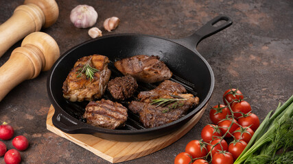 The different types of fried steak in frying pan, close up view. Vegetables, herbs, spices