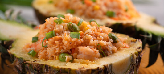 Carved pineapple stuffed with fresh pineapple tomato sauced seafood fried rice.