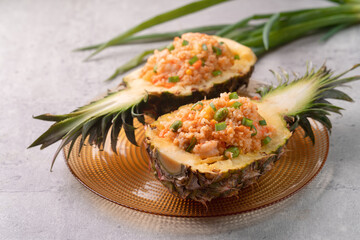 Carved pineapple stuffed with fresh pineapple tomato sauced seafood fried rice.