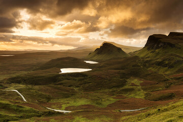 Scenic view of Quiraing mountains in Isle of Skye, Scottish highlands, United Kingdom. Sunrise time with colourful an rayini clouds in background.