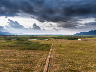 Scenic landscape aerial view of field river and basin against a natural mountain, Drone shot tropical landscape with noise and grain processed