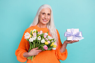 Photo of nice happy old woman hold gift box flowers good mood holiday isolated on teal color background