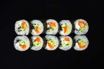 salmon futomaki rolls on black