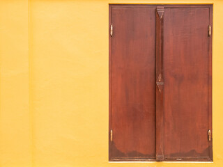 brown wood window on yellow wall.