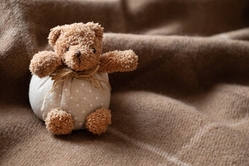 Cute teddy bear toy on warm blanket. Kids bedroom interior