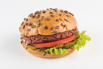 Vegan burger with beetroot patty on white background, isolated. Fast food for a meat-free diet.