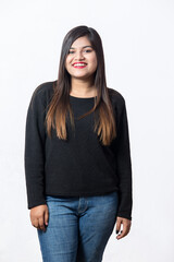 3 by 4 length photo of an Indian girl wearing black topper and blue denim jeans  posing for modelling photo shoot in studio against white background