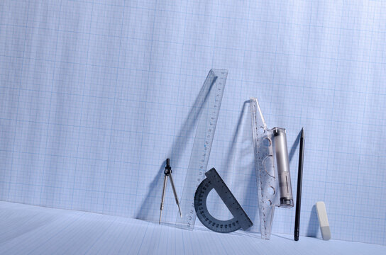 Transperent professinal scales, rulers, pencil, eraser, t-square on the blank blue paper