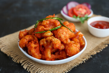 Gobi Manchurian dry, Gobi 65 with tomato sauce popular Indian street food snack Delhi Mumbai India made cauliflower florets Veg Manchurian chilly gobi Indo Chinese side dish chapati roti