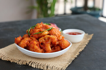 Gobi Manchurian dry, Gobi 65 with tomato sauce popular Indian street food snack Delhi Mumbai India made cauliflower florets Veg Manchurian chilly gobi Indo Chinese side dish chapati roti