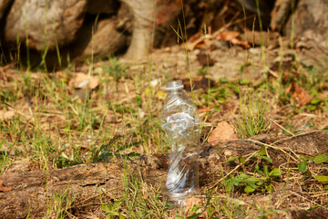 Naklejka na ściany i meble a plastic bottle lies on grass in nature like garbage