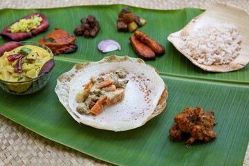 Appam with mutton stew Non-vegetarian sadhya Indian food for Onam sadya Christmas Easter celebration Kerala India Sri Lanka hoppers beef fry fish curry rice on banana leaf